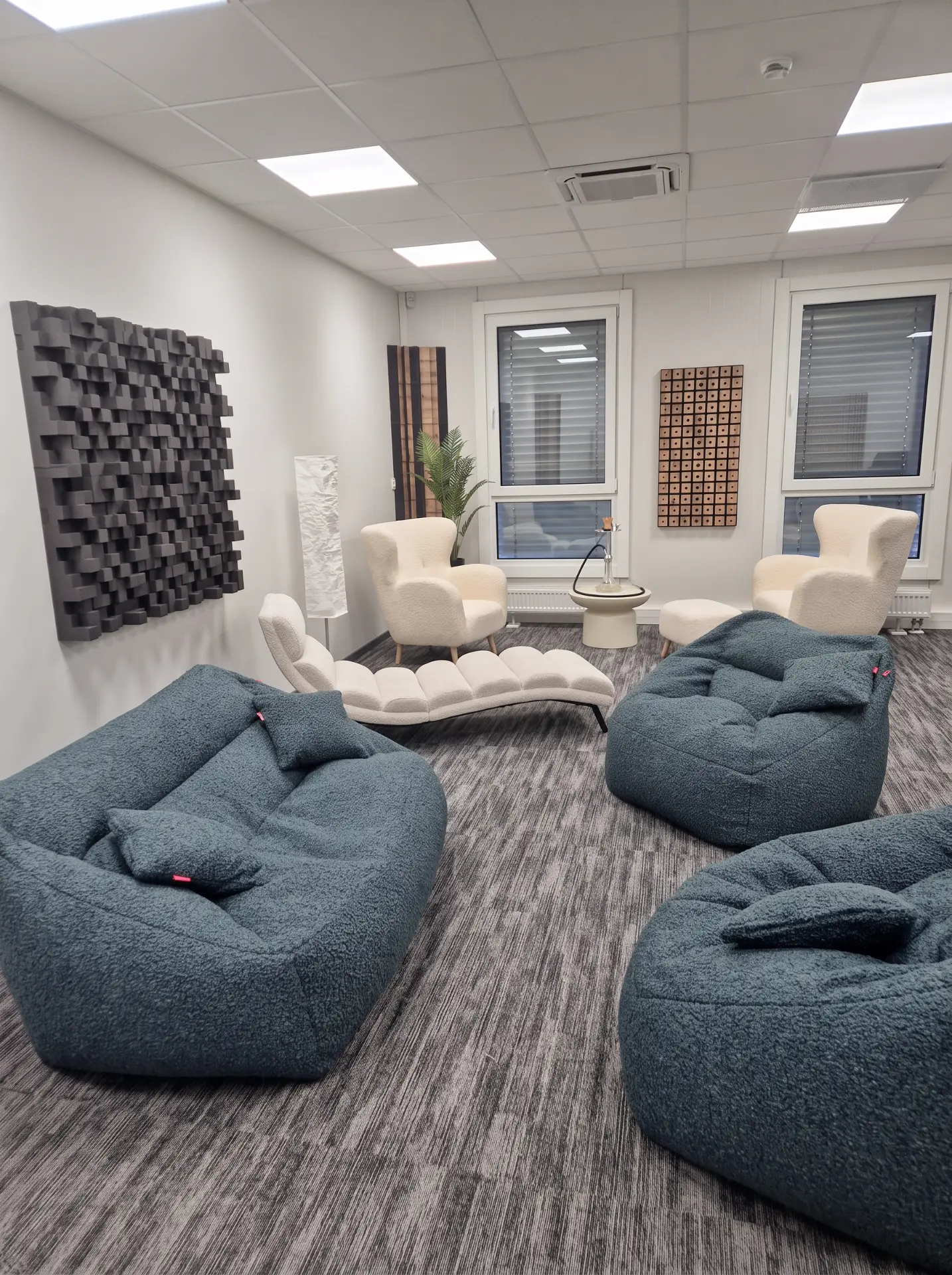 Studio overview with blue lounge seating, cream armchairs and acoustic wall panels